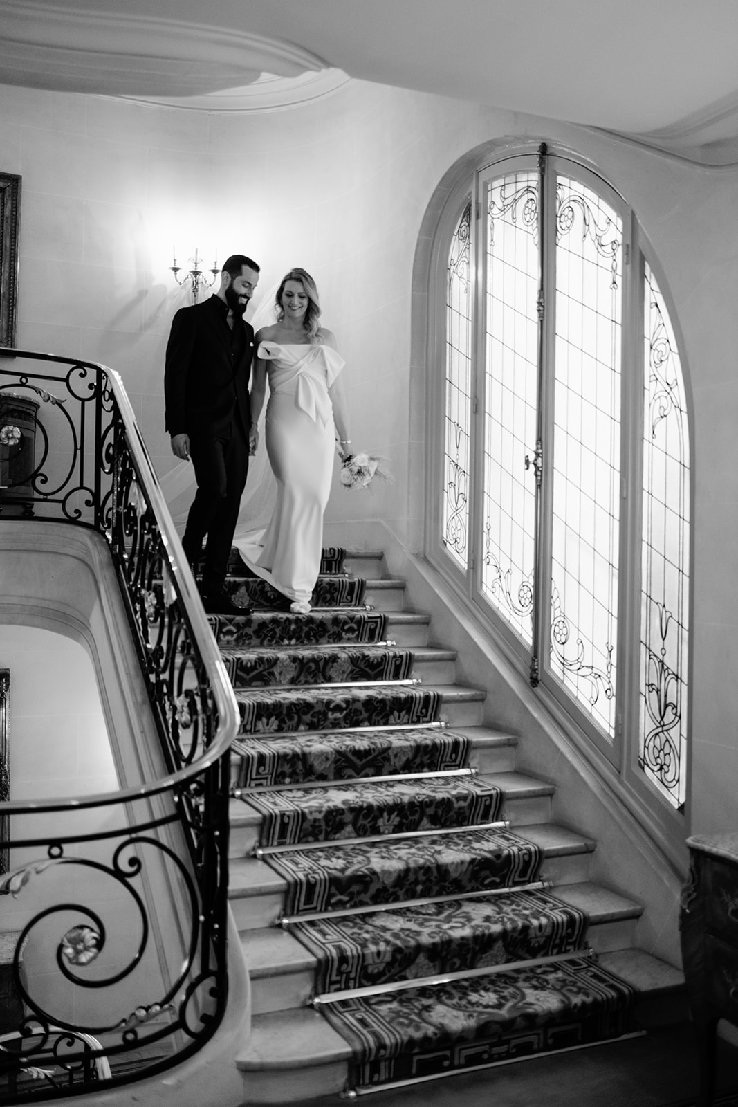 Bride and groom descending the grand staircase at Hôtel Plaza Athénée Paris